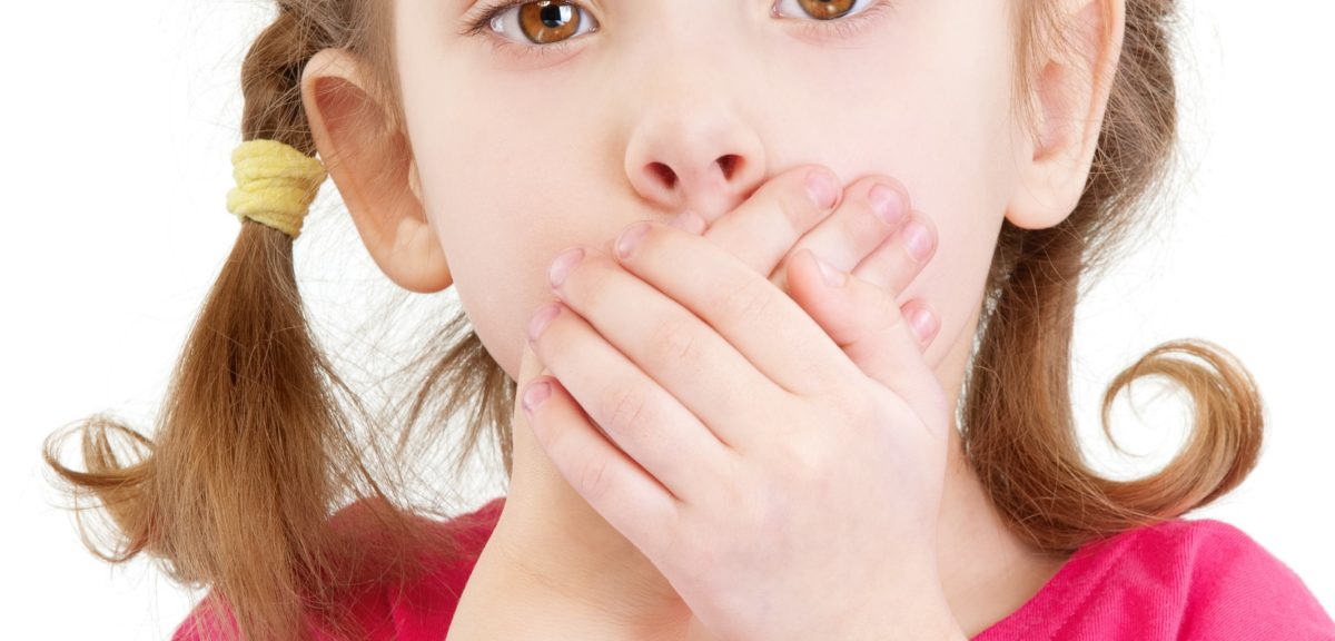 une petite fille avec mains sur la bouche